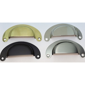 May include: Four cabinet pulls in different finishes: brass, polished nickel, black, and brushed nickel. Each pull is a half-circle shape with rounded edges.