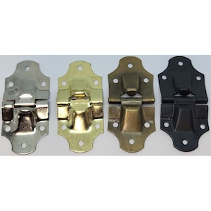 May include: Four metal hinges in different finishes: silver, gold, brass, and black. Each hinge has a decorative design and is suitable for use on furniture, boxes, or other projects.