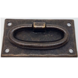 May include: A rectangular metal handle with a rounded oval pull. The handle is a dark bronze color with a slightly distressed finish.