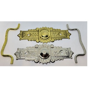 May include: Two ornate metal decorative plates with a domed center, one gold and one silver, with two matching metal hooks.