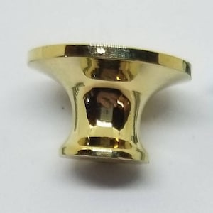 Puede incluir: Un pomo de armario dorado con la parte superior redonda y un tornillo para la instalación. El tornillo es de color plateado.