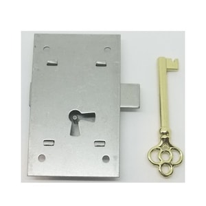 May include: A silver metal door lock with a keyhole and a matching key. The key is gold colored and has a decorative design.