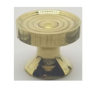 May include: A gold-toned metal knob with a round, fluted top and a flared base.