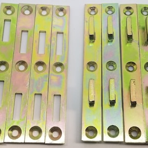 May include: Set of ten gold metal shelf brackets with slots and hooks. The brackets are designed to be used for hanging shelves or other items.