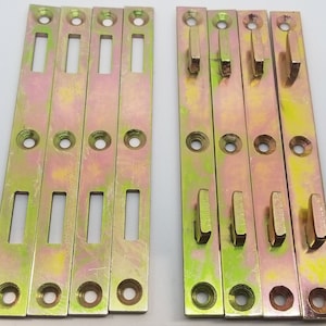 May include: Ten gold metal shelf brackets with holes for screws. The brackets have a rectangular shape with a small rectangular cutout in the center.