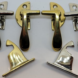 May include: Two sets of antique-style cabinet door latches. One set is polished brass, the other is polished nickel. Each set includes a handle, a hook, and a mounting plate.