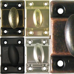 May include: Four cabinet door catches in different finishes: antique brass, polished brass, satin nickel, and oil rubbed bronze. Each catch has a rounded oval pull and four screw holes.