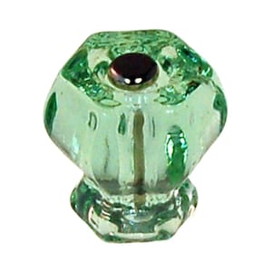 May include: A green glass cabinet knob with a hexagonal shape and a silver metal base.