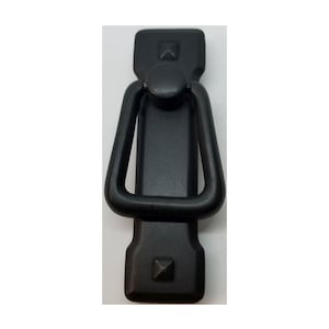 May include: Black metal cabinet pull with a square shape and a ring handle. The pull has a textured finish and two small square accents at the top and bottom.