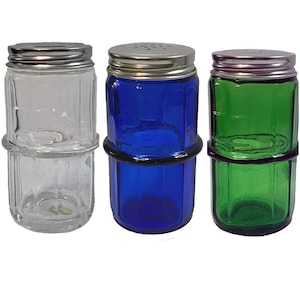 May include: Three glass salt and pepper shakers with metal lids. One is clear, one is blue, and one is green. Each shaker has a black rubber ring around the middle. The lids have small holes for dispensing.