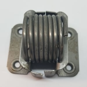 May include: A silver metal spring hinge with a rectangular base and four holes. The spring is coiled and has a silver finish.
