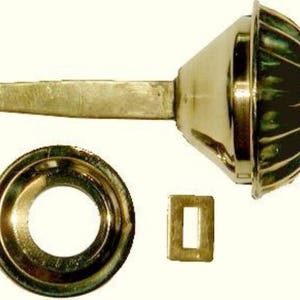 May include: A set of three gold-toned metal door hardware pieces. The main piece is a round knob with a fluted design. The second piece is a round plate with a hole in the center. The third piece is a rectangular plate.