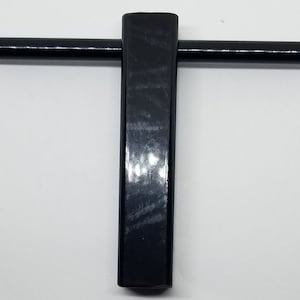 May include: A black metal T-shaped wrench with a square head and a long handle.
