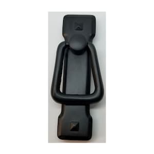 May include: Black metal cabinet pull with a square shape and a ring handle. The pull has a slightly textured finish.