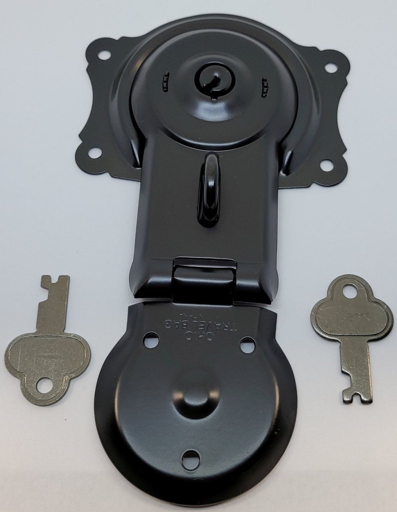 May include: Black metal latch with a keyhole and a small metal loop. The latch is in two pieces, one with a round base and the other with a rectangular base. Two silver keys are included.