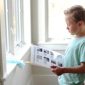 May include: A young boy is looking at a checklist titled "Mission Possible" with pictures of household chores. The checklist is on a white background with blue text and images.