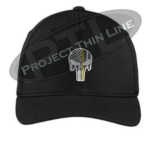 Op de afbeelding: Zwarte baseballpet met een wit en geel Amerikaans vlag Punisher-schedelontwerp. De schedel heeft een dunne gele lijn eroverheen. De tekst "PROJECT THIN LINE" is zichtbaar op de pet.
