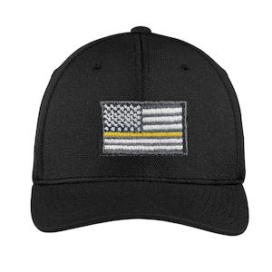 Op de afbeelding: Zwarte baseballpet met een dunne gele lijn Amerikaanse vlag geborduurd op de voorkant.