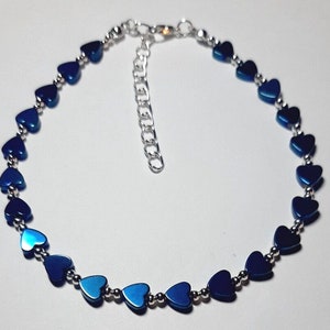 May include: A blue heart-shaped bead anklet with a silver chain extender.