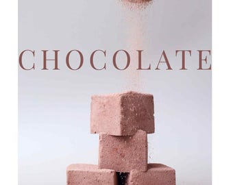 Puede incluir: Una pila de cuatro bloques de chocolate cuadrados, de color marrón claro. Se sostiene un tamiz metálico encima, con polvo de chocolate cayendo sobre los bloques. La palabra "CHOCOLATE" está impresa en marrón.