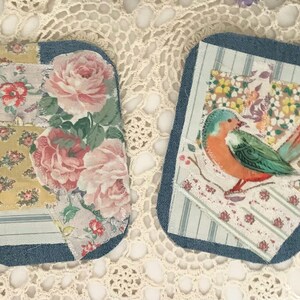 May include: Two decorative fabric patches with denim edges. One features a floral design with pink roses and red accents. The other has a colorful bird illustration on a patchwork background with floral and striped patterns.