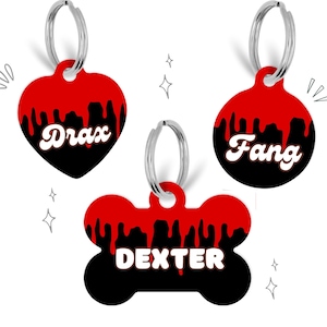 May include: Three dog tag pendants with red dripping paint and black backgrounds. The tags are shaped like a heart, a circle, and a bone. The names "Drax", "Fang", and "Dexter" are written in white on the tags.