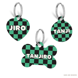 May include: Three pet ID tags with a green and black checkered pattern and silver split rings. One tag is heart-shaped with the name JIRO, one is circular with the name TANJI, and one is bone-shaped with the name TANJIRO. Text BARK AND WHISKERS is present.