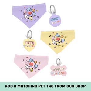 May include: Three different pet bandanas with matching pet tags. The bandanas are purple, yellow, and pink with a cartoon design of characters from the K-pop group BTS. The tags are purple, yellow, and pink with the names "Lucky", "Tata", and "Cooky" on them.