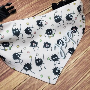 May include: A white bandana with a black and white print of cartoon creatures with stars. The bandana has the name "Jeep" written in white on it.