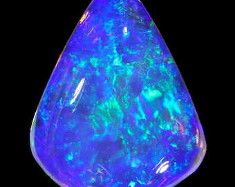 May include: A polished, teardrop-shaped opal gemstone. The stone displays a vibrant play-of-color, with swirling patterns of blue, green, and hints of purple. The gemstone is set against a black background, highlighting its iridescent qualities.