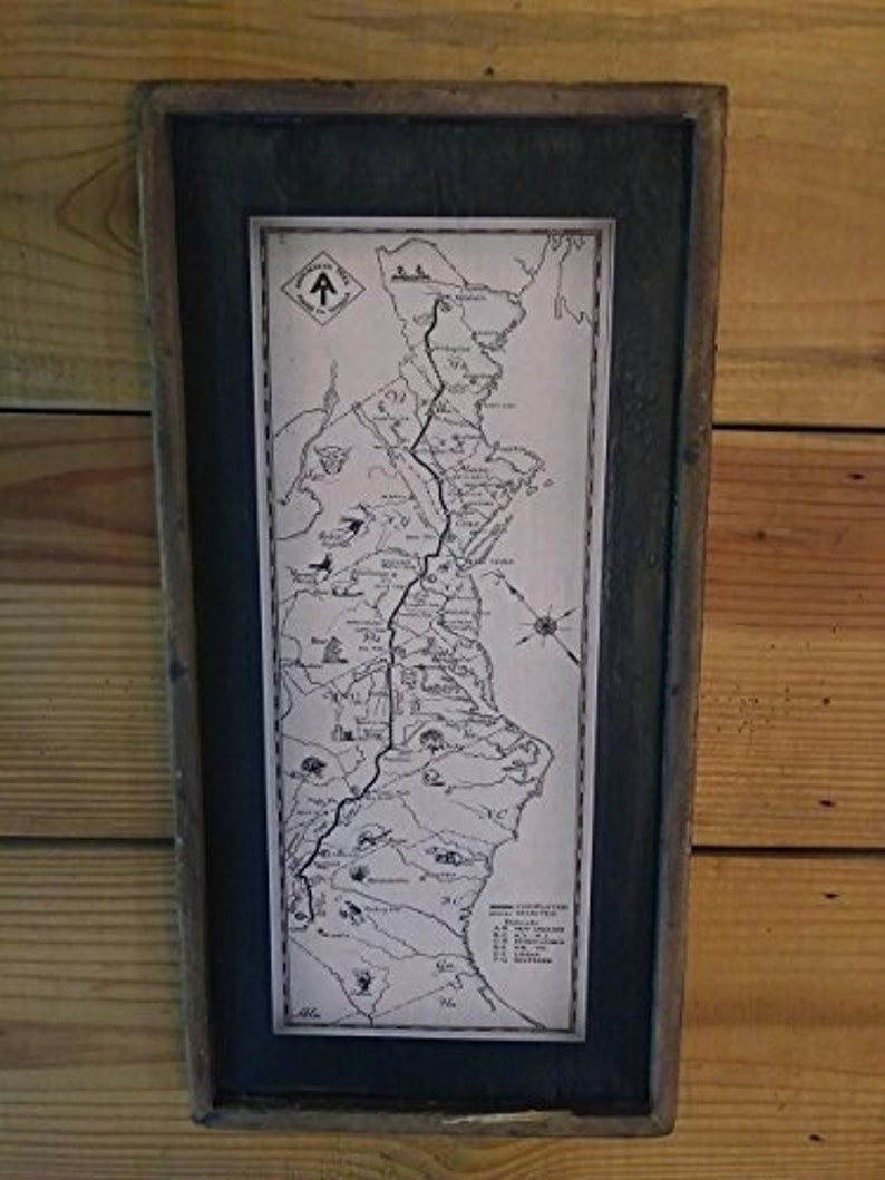 May include: A framed black and white map of a hiking trail with the text "Appalachian Trail" at the top. The map shows the trail winding through a mountainous region with various points of interest marked along the way.