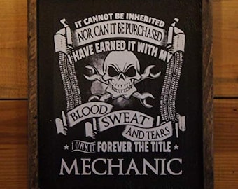 May include: Black and white sign with a skull and crossbones graphic and the text "IT CANNOT BE INHERITED NOR CAN IT BE PURCHASED I HAVE EARNED IT WITH MY BLOOD SWEAT AND TEARS *I OWN IT FOREVER THE TITLE* MECHANIC"
