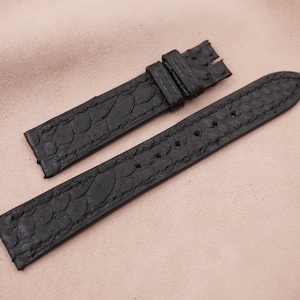 May include: Two black leather watch straps with a textured pattern. The straps are made of genuine leather and have a classic look.
