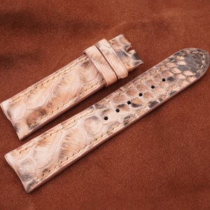 May include: A light brown leather watch strap with a textured snake skin pattern.