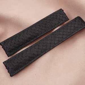 Puede incluir: Dos correas de reloj de cuero negro con un patrón texturizado.