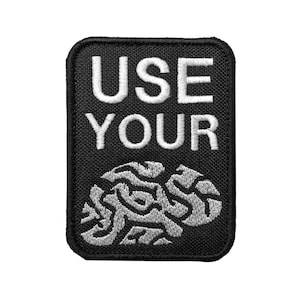 May include: Black embroidered patch with white text that reads "USE YOUR" and a white embroidered brain graphic.