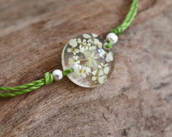 dainty flower bracelet with real cow's parsley in eco epoxy resin and green macrame string, size adjustable