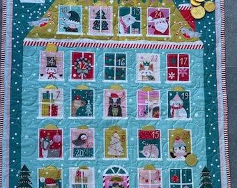 Könnte beinhalten: Ein blauer und rosa gesteppter Adventskalender mit 24 nummerierten Fenstern, die jeweils ein anderes Tier oder ein festliches Motiv zeigen. Der Kalender ist mit Schneeflocken und goldenen Münzen verziert.