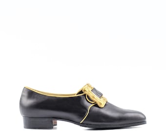 Zapato de hombre de piel negra estilo rococó, con ribete dorado, estilo siglo XVIII.
