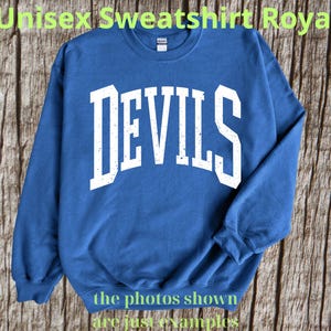 Puede incluir: Sudadera unisex azul real con la palabra "DEVILS" en letras blancas grandes y desgastadas en el pecho. La sudadera tiene mangas largas y cuello redondo. El texto "the photos shown are just examples" está en la parte inferior.