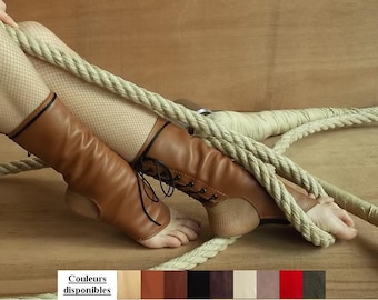 Peut inclure: Bottes sans pied en cuir marron clair à lacets avec bordures et lacets noirs, portées sur des collants résille beiges. L'image inclut une palette de couleurs intitulée "Couleurs disponibles" présentant dix échantillons de couleurs.
