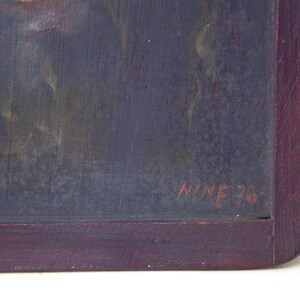 May include: A close-up of a dark gray chalkboard with a red wooden frame. The chalkboard has a faint image of a person's face and the text "NINE 76" written in red.