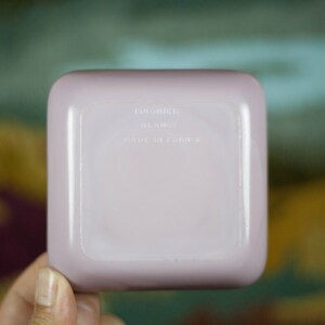 May include: A square, pale lavender ceramic dish with the text "Made in France" on the bottom.