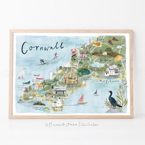 May include: Watercolor map print of Cornwall, England, with a light wood frame. The map features illustrations of landmarks, boats, and surfers, with the word "Cornwall" at the top. The artwork is signed by the artist.