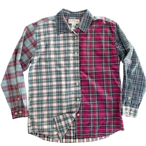 May include: A long-sleeve button-down shirt featuring a color-blocked plaid pattern. The left side is a light cream, teal, and navy plaid, while the right side is a vibrant magenta, navy, and green plaid. The collar tag displays the text ORVIS.