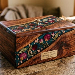 A decorative, live-edge wood and floral resin storage box is centered on a rustic wooden table.