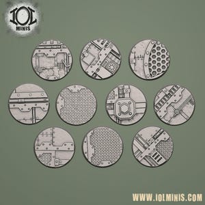 Könnte beinhalten: Eine Sammlung von neun kreisförmigen Sockeln mit einem metallischen, industriellen Design. Jeder Sockel weist ein einzigartiges Muster aus Nieten, Rohren und mechanischen Komponenten auf, ideal für Miniatur-Wargaming oder Modellbau. Die Sockel sind grau und haben eine strukturierte Oberfläche.
