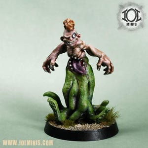 Könnte beinhalten: Handbemalte Miniaturfigur einer grotesken Kreatur mit Irokesenschnitt, freiliegendem Brustkorb und grünen Tentakeln. Die Figur ist auf einem schwarzen Sockel mit Gras und dem Text "www.iolminis.com" montiert. Die Figur hat einen bedrohlichen Ausdruck.