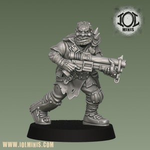 Può includere: Figura in miniatura dettagliata di un personaggio fantasy, che tiene in mano una grossa pistola. La figura è vestita con armatura e stivali, con una barba strutturata e spalline a punta. La figura è su una base nera, con il sito web "www.iolminis.com" visibile.