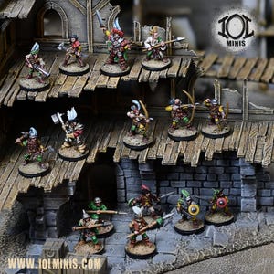 Puede incluir: Figuras en miniatura de personajes de fantasía, incluyendo arqueros, lanceros y guerreros con espadas. Las figuras están pintadas con ropa y accesorios detallados, de pie sobre una estructura de madera y una base de piedra. La marca es "IOL MINIS".